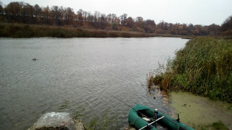 Рыбак сидя на берегу реки видит на гладкой поверхности воды изображение утреннего солнца