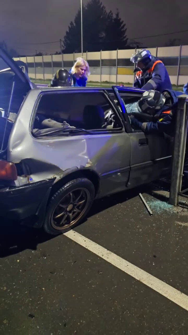 Пострадавшего водителя деблокируют из машины и оказывают первую помощь 